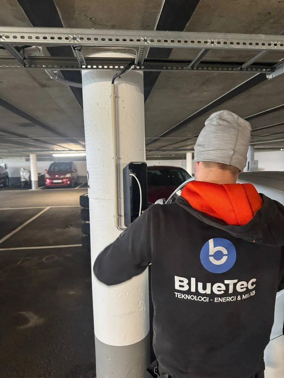 BlueTec-montør jobber på lader i parkeringskjeller